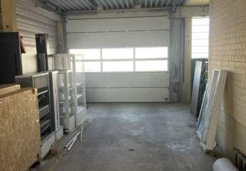 Lagerhalle mit überdachter Ladezone und großem Außenbereich.