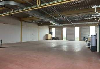 Lagerhalle mit überdachter Ladezone und großem Außenbereich.